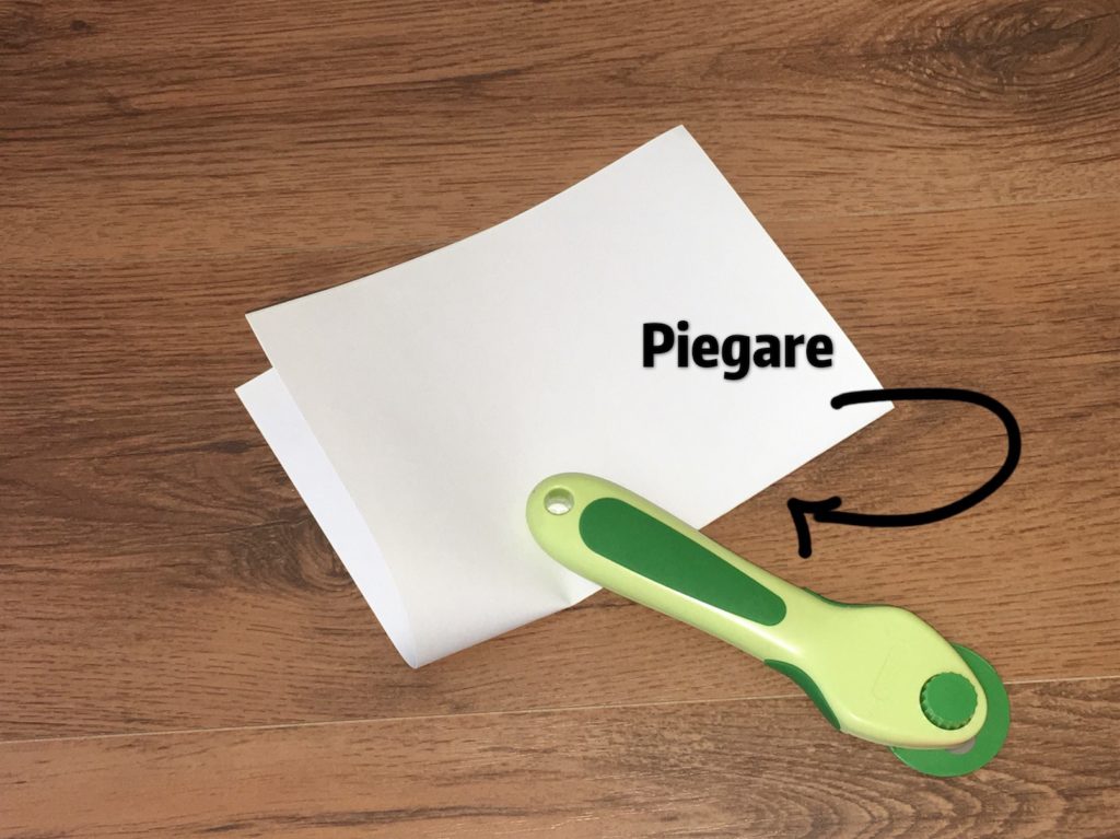 Piegate al centro i fogli di carta scelti per il quaderno