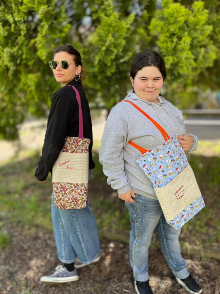 Elena e Chiara indossano la shopper realizzata in collaborazione con ipsia